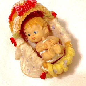 Vintage miniature resin baby in a basket, drinking a bottle